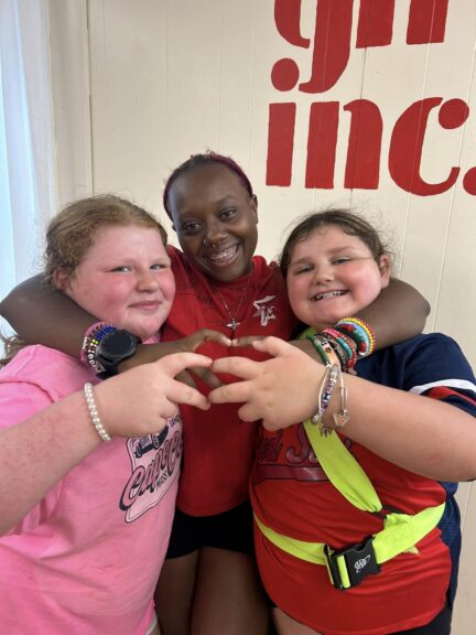 3 young smiling girls posting for a photo